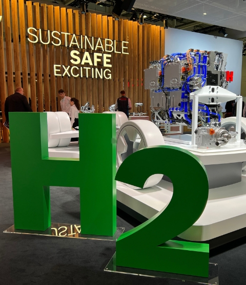 Stand with wooden panel and giant green letters H2 in foreground