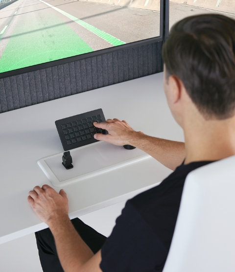 man from behind, using a keyboard for a driving simulator