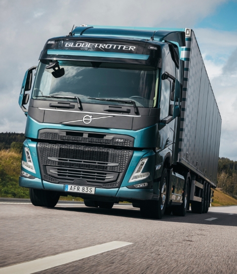 blue globetrotter truck driving fast on a concrete road